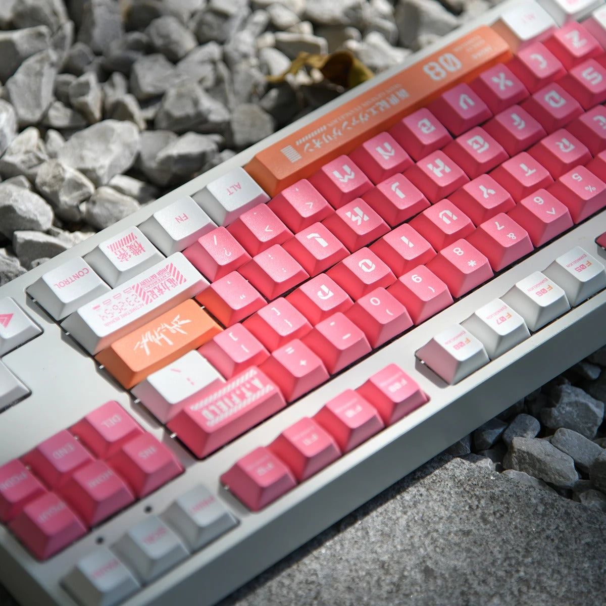 A pink and white mechanical keyboard with Japanese characters and symbols on the keys.
